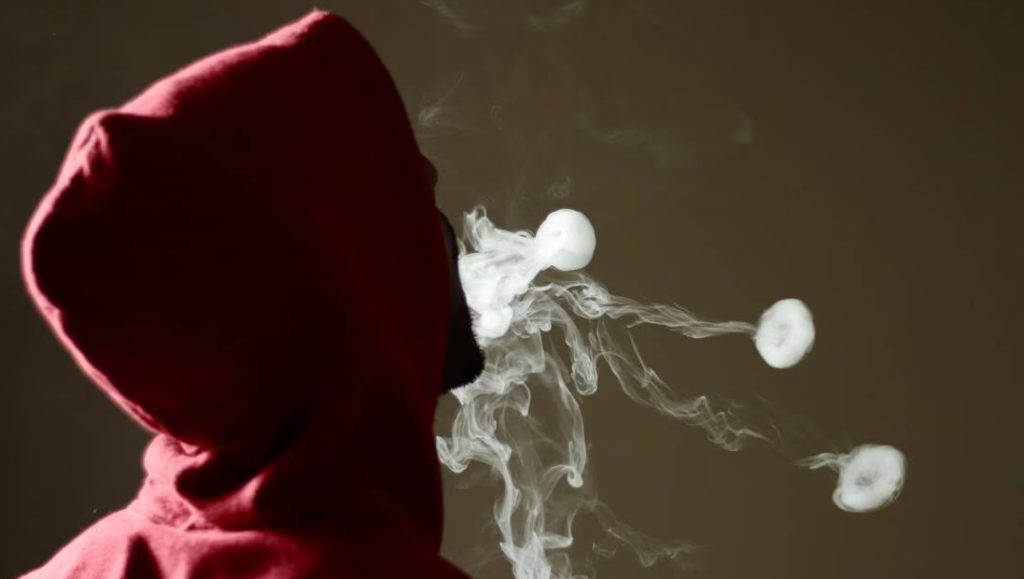 Loophole in NZ Vaping Law Allows Sales Near Schools and Marae Person vaping near school sign